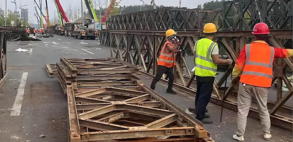 A temporary Bailey bridge with workers and materials